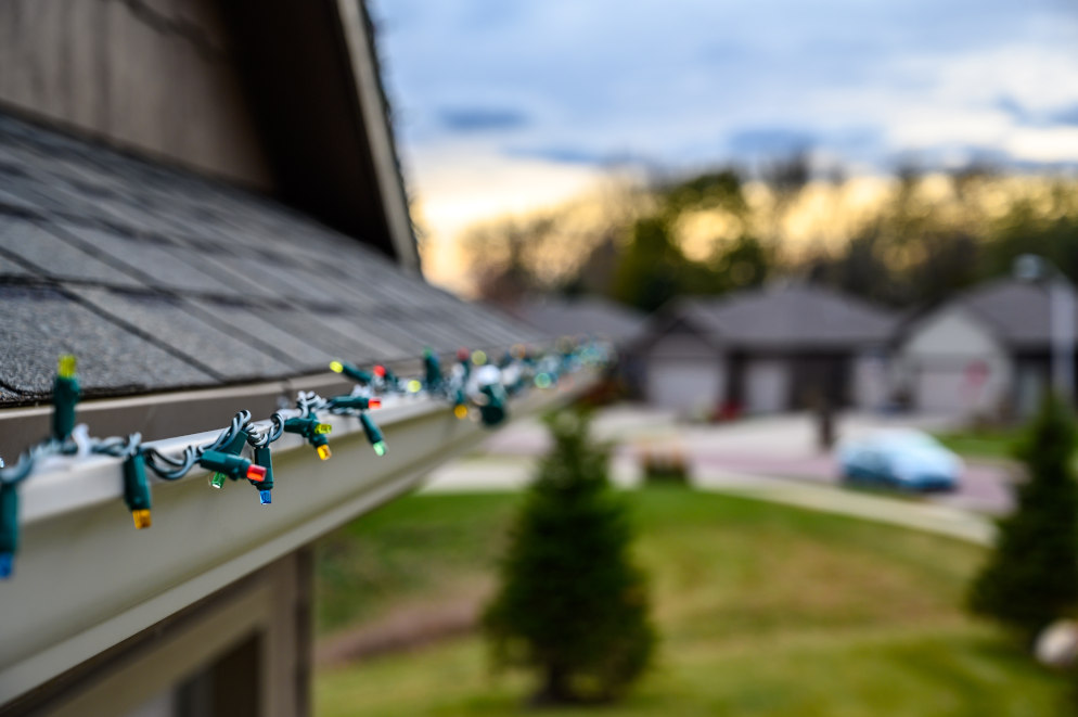 Hanging Christmas lights on gutter edge with plastic clips